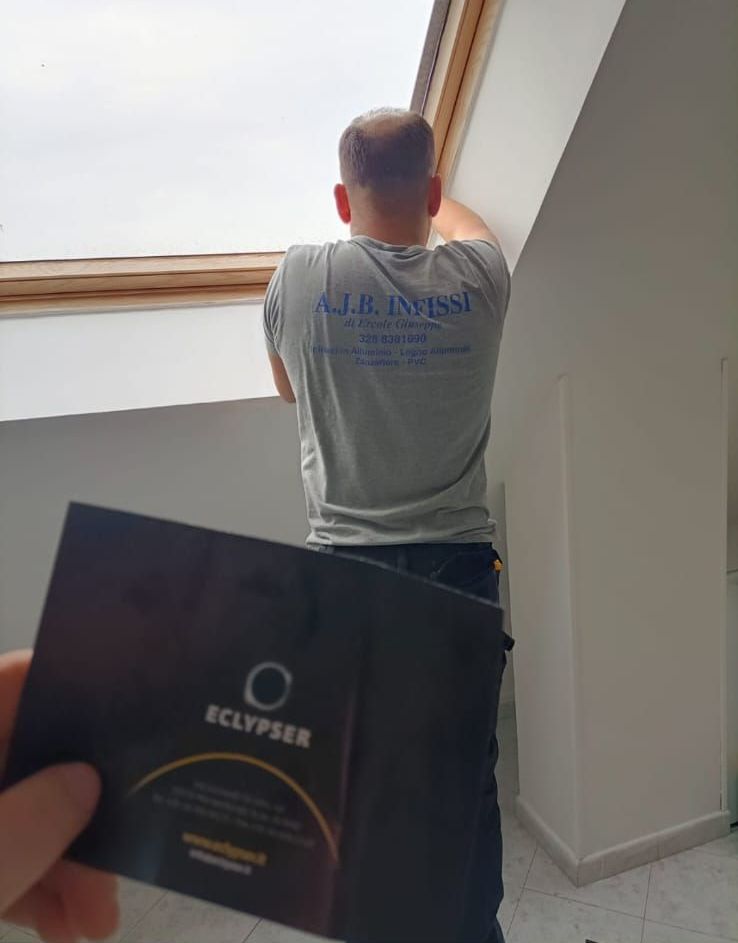 Un uomo è in piedi davanti a un lucernario con in mano un biglietto da visita.