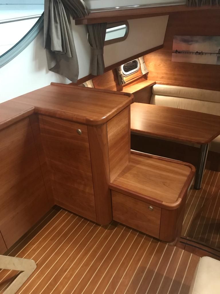 zithoek en opbergsysteem van hout gelakt met ronde hoeken op een cruiser jacht boot
