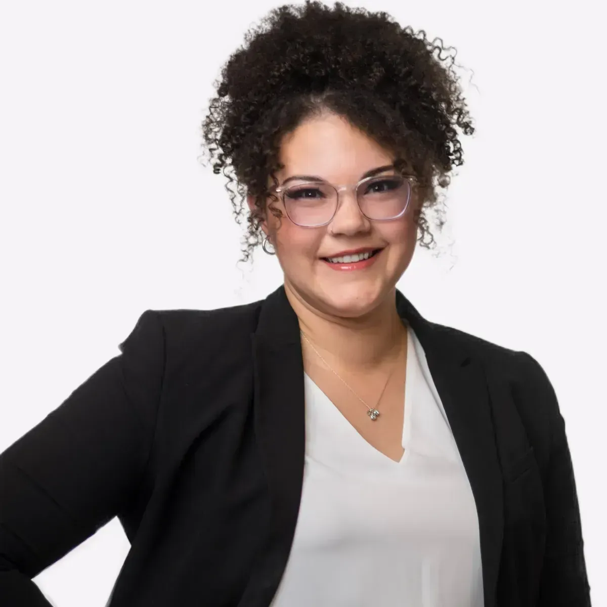 A woman wearing glasses and a black jacket is smiling for the camera.