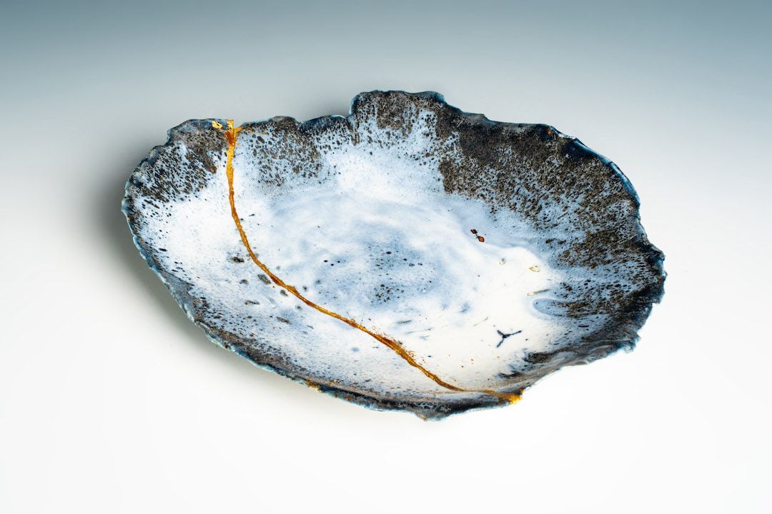 A black and white plate with a gold line on it is sitting on a table.