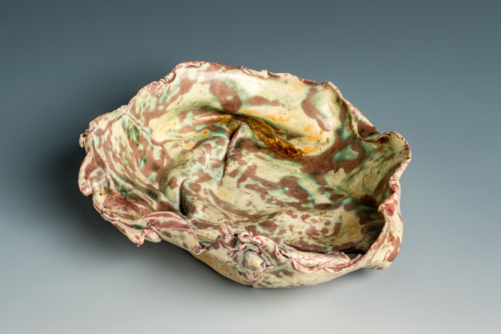 A colorful ceramic bowl is sitting on a gray surface.