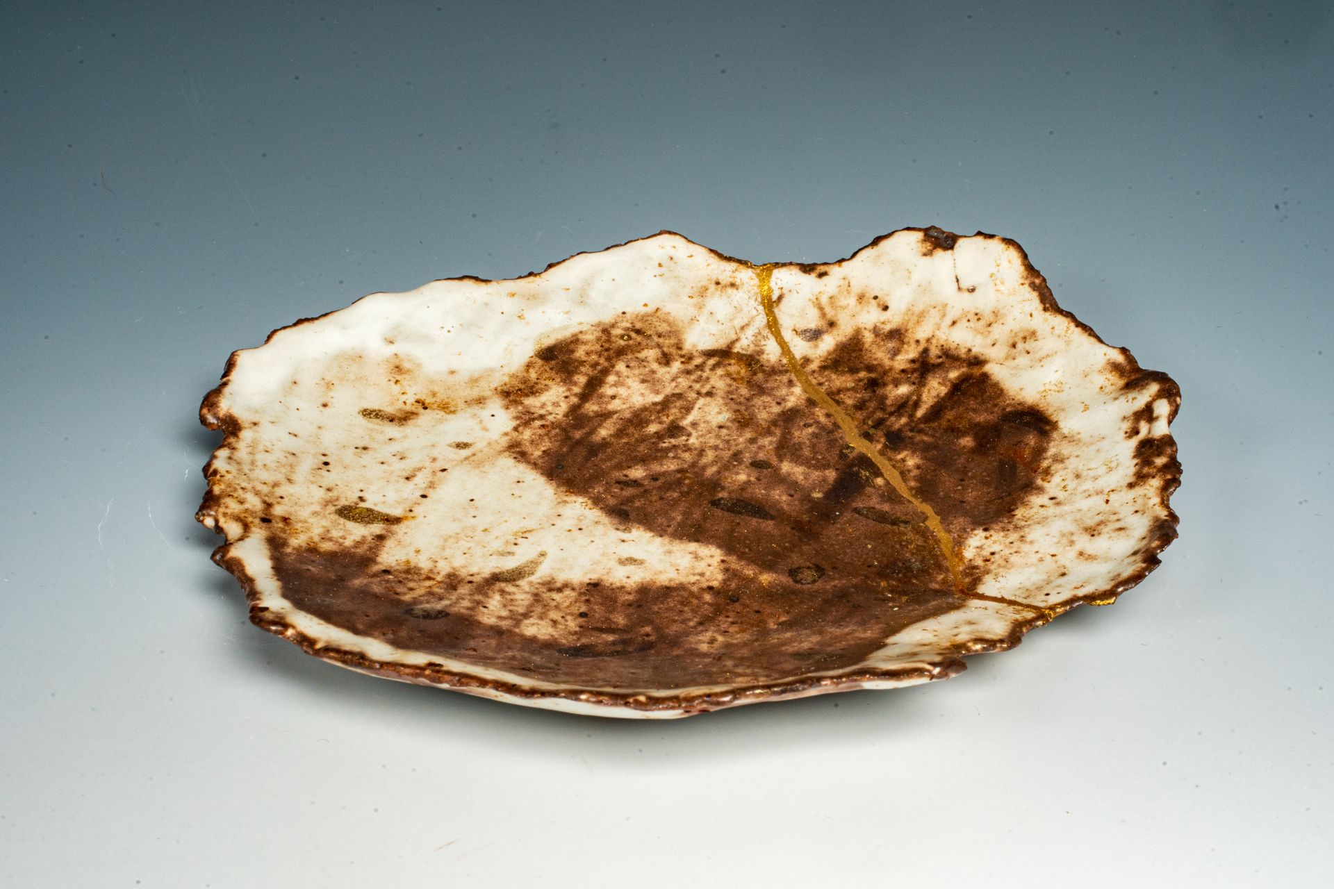 A white plate with a brown leaf on it