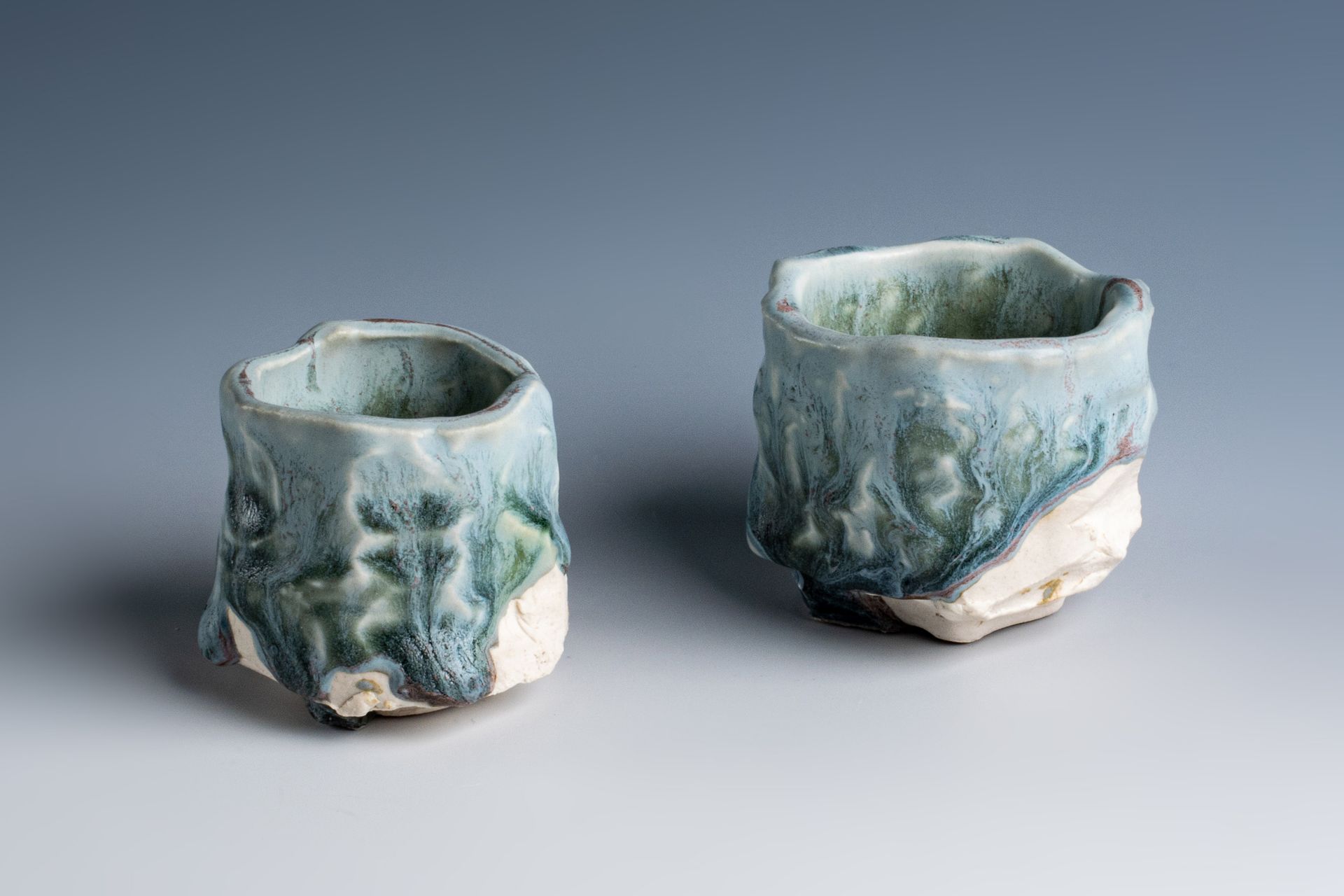 Two ceramic cups are sitting next to each other on a table.