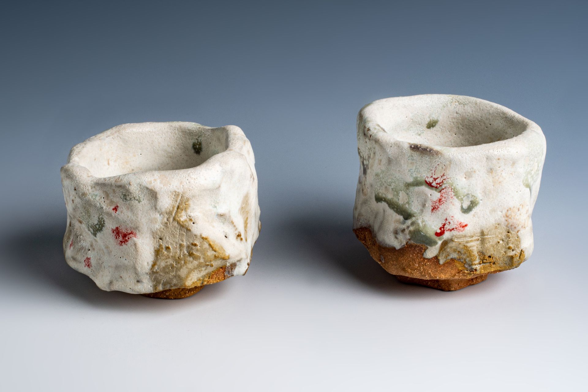 Two ceramic cups are sitting next to each other on a table.