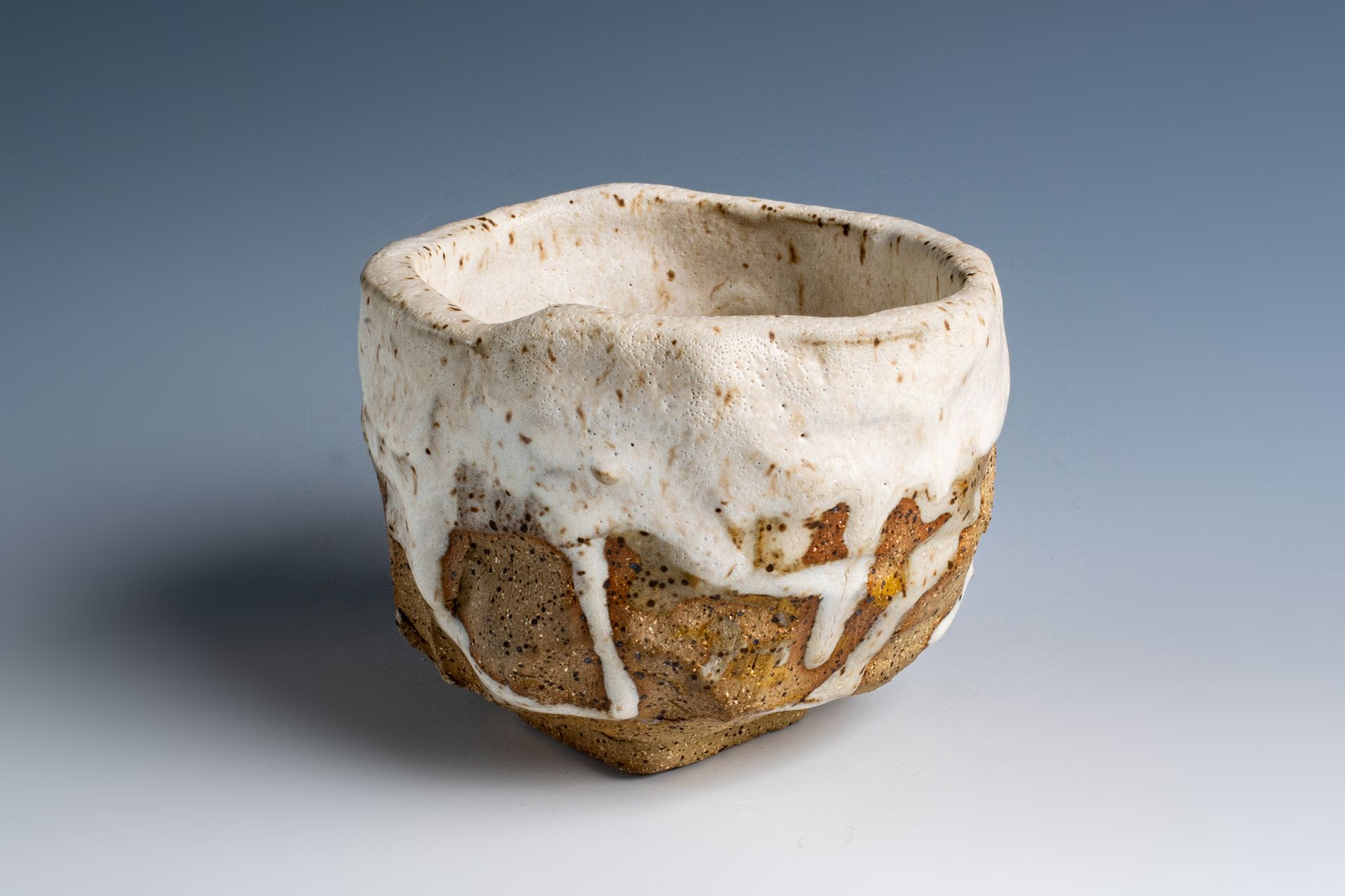 A small white and brown bowl is sitting on a table.
