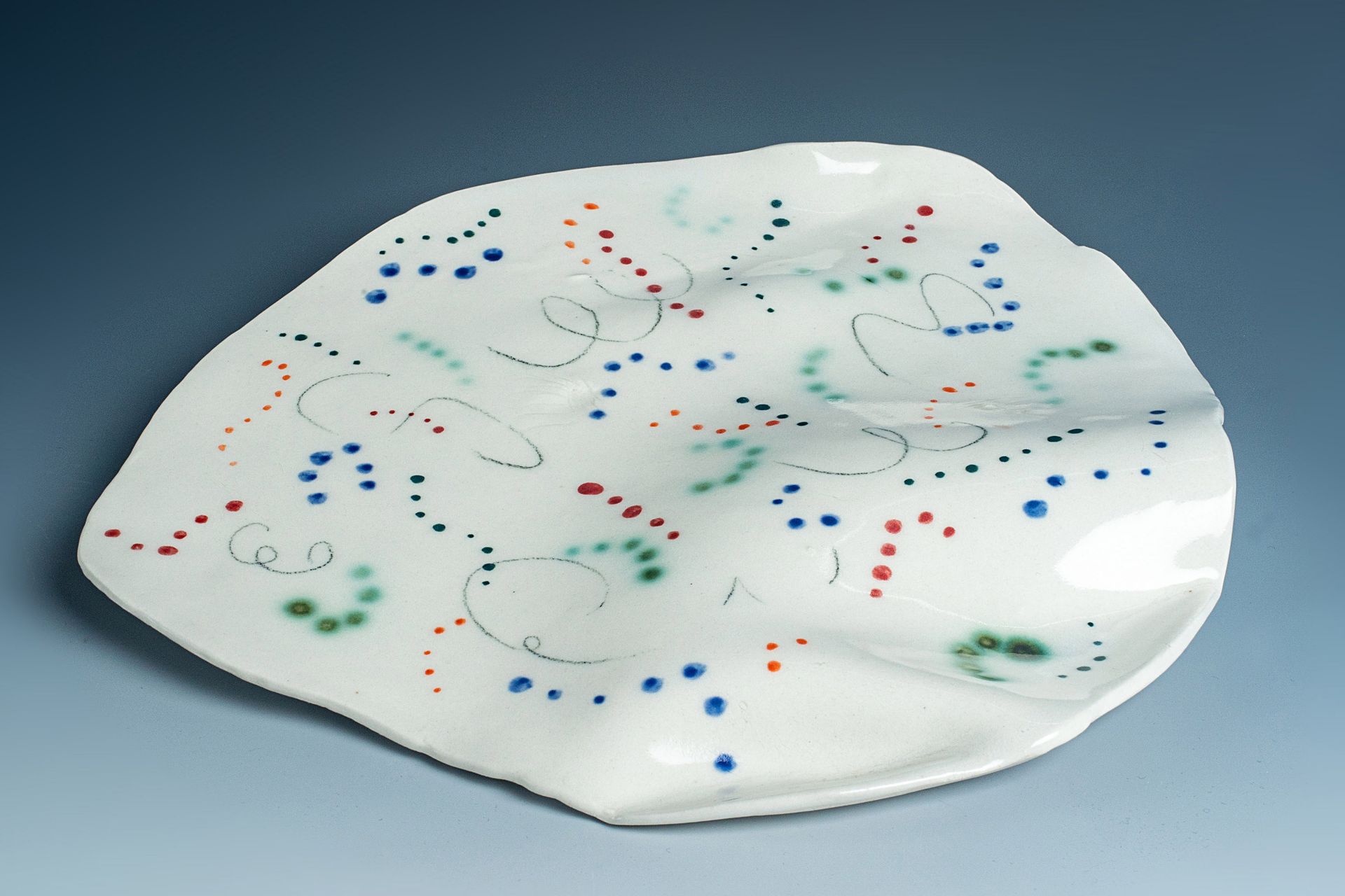 A white plate with colorful dots and swirls on it