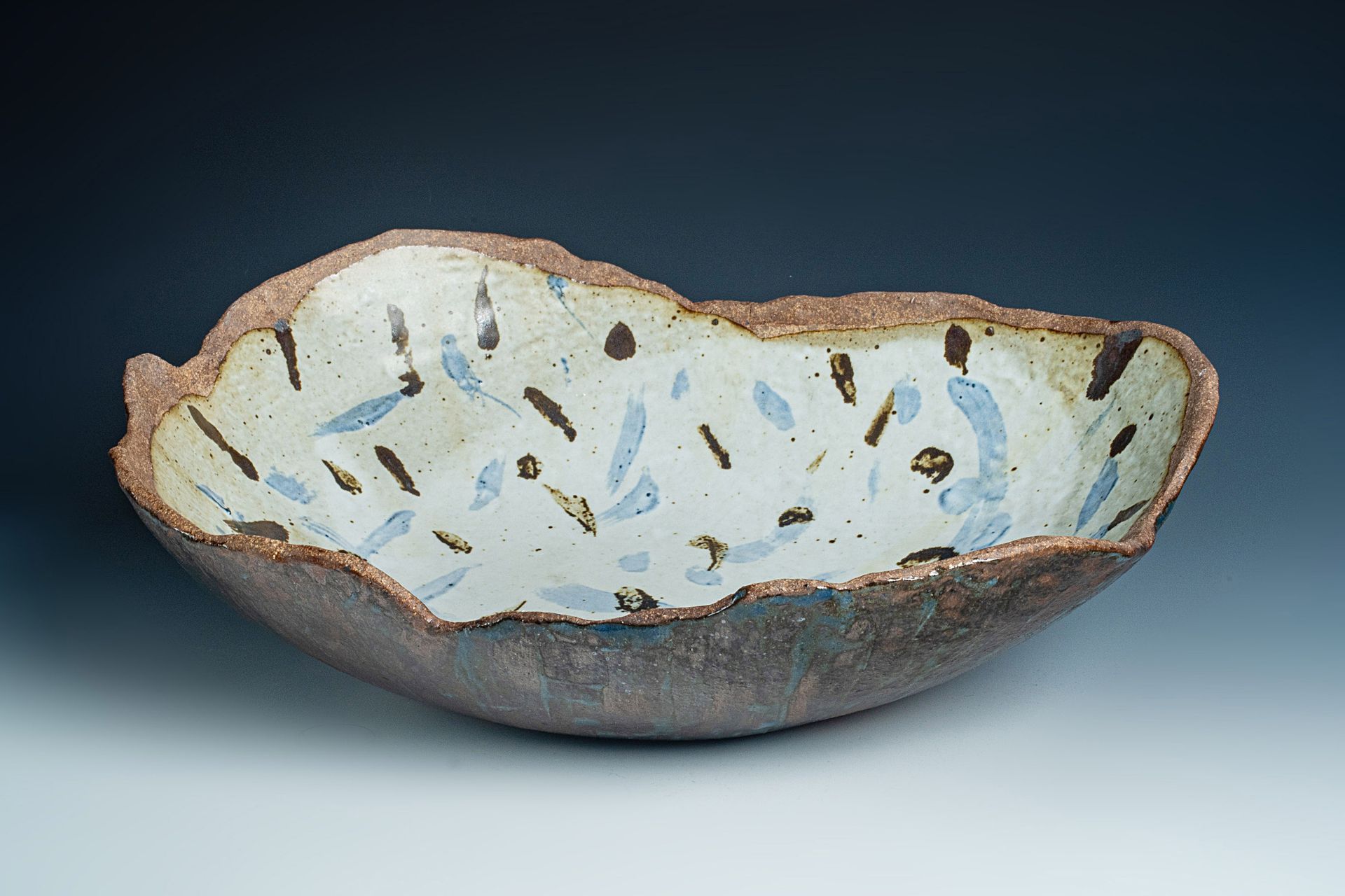 A brown and white bowl with blue spots on it