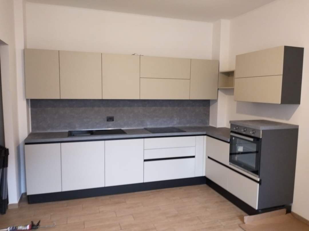 Una cucina con mobili bianchi e un forno nero