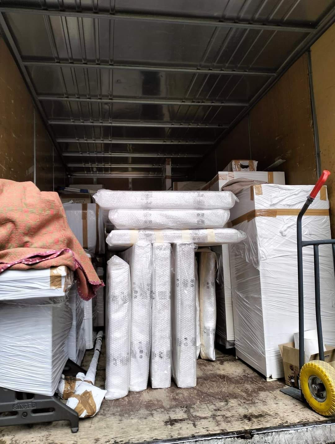 Il retro di un camion pieno di scatole e materassi.