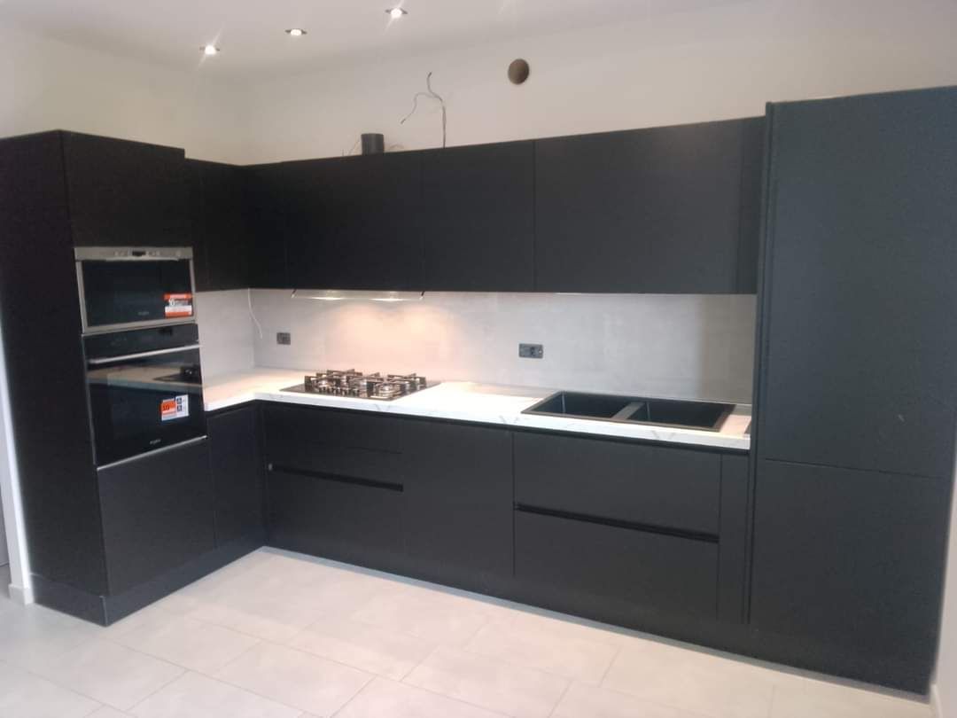 Una cucina con mobili neri e un forno sul piano cottura