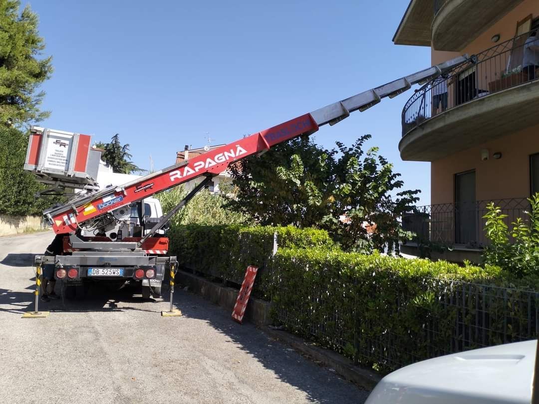 Un camion rapagna rosso e bianco è parcheggiato davanti a un edificio