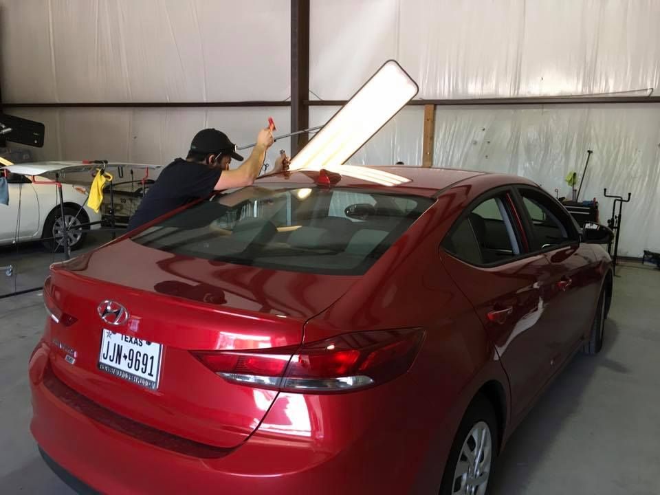 A Man Fixing Roof Of The Car - Aurora, CO - Elevate Hail & Dent Repair