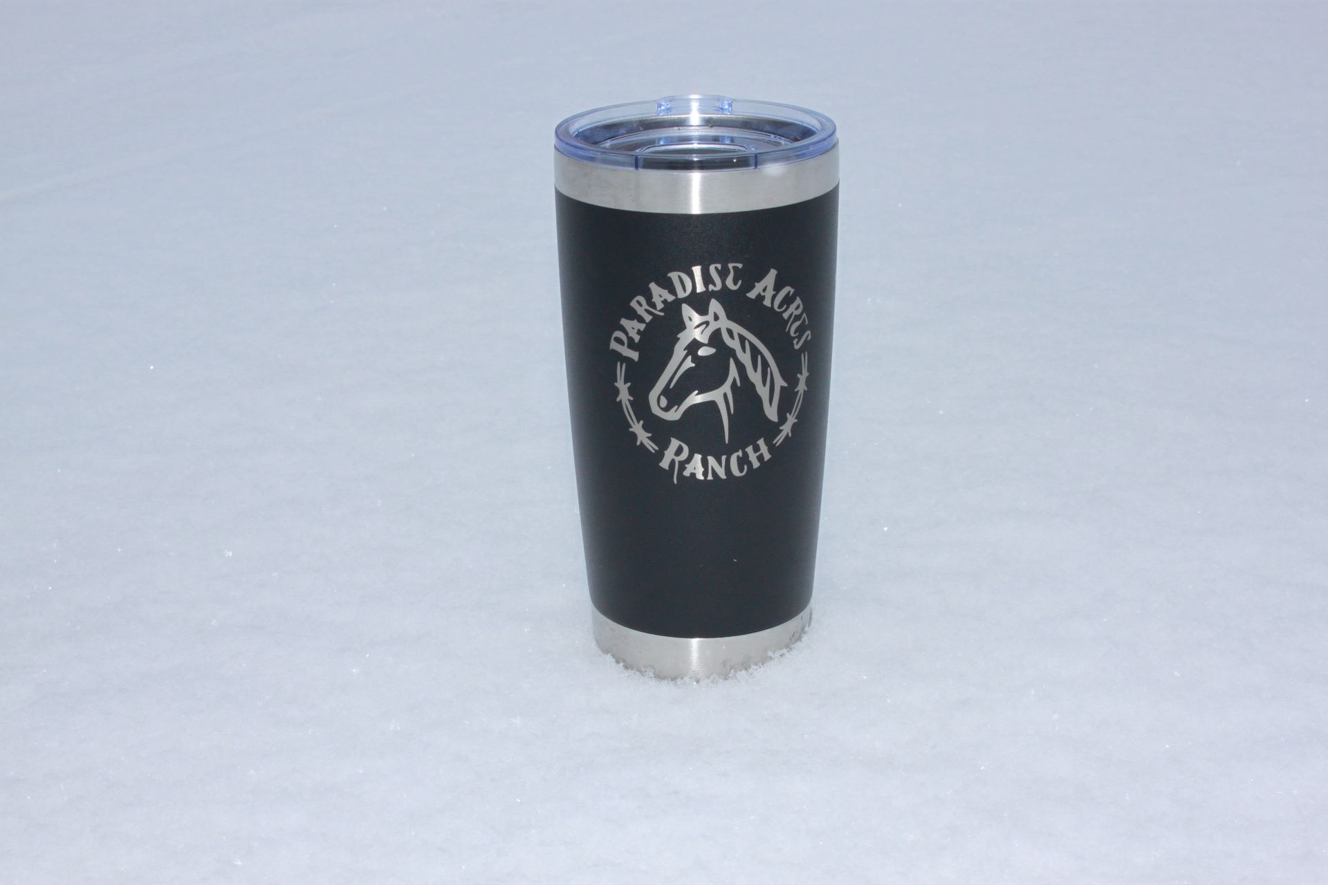 Top-down view of a silver travel mug with an open black slider lid.