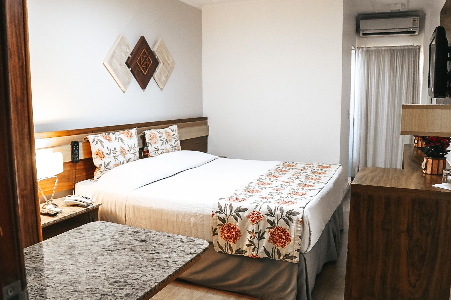 Um quarto de hotel com uma cama king size e uma cômoda.