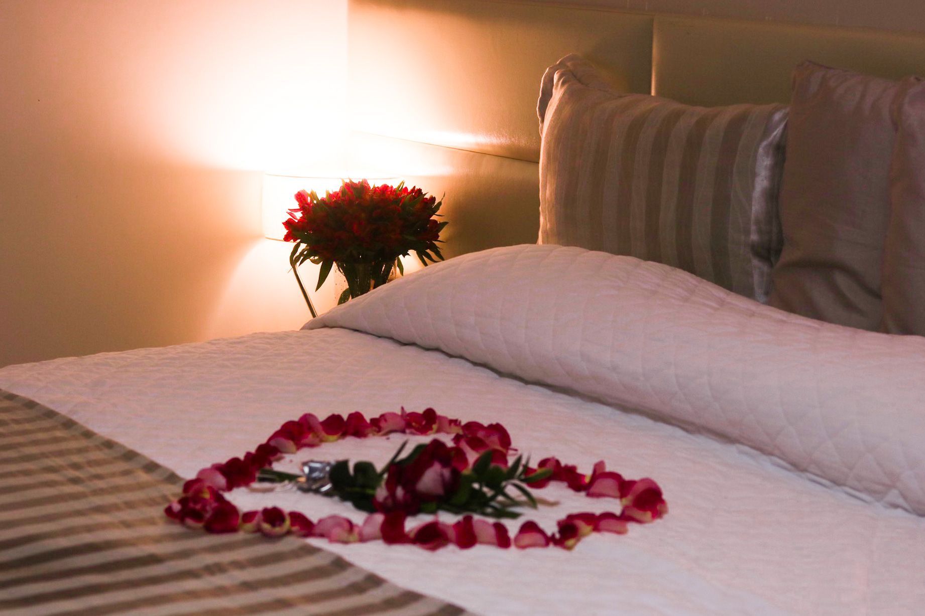 Uma cama com um coração feito de pétalas de rosa