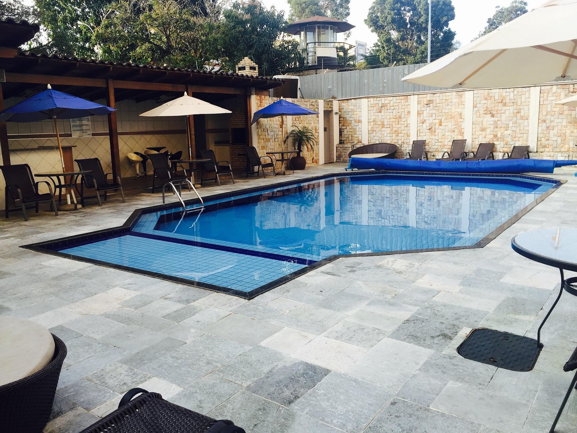 Uma grande piscina com guarda-sóis e cadeiras ao redor