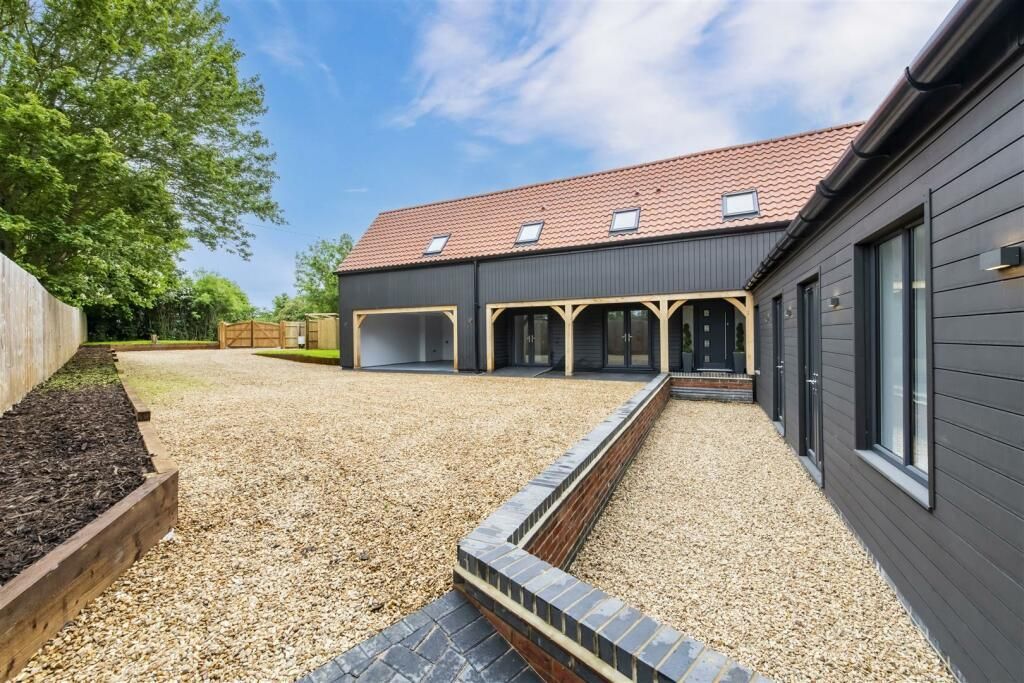 A large house with a gravel driveway in front of it