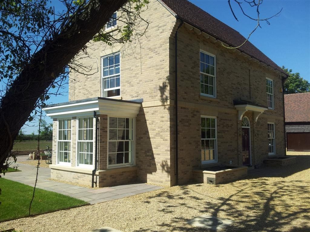 A large brick house with a tree in front of it