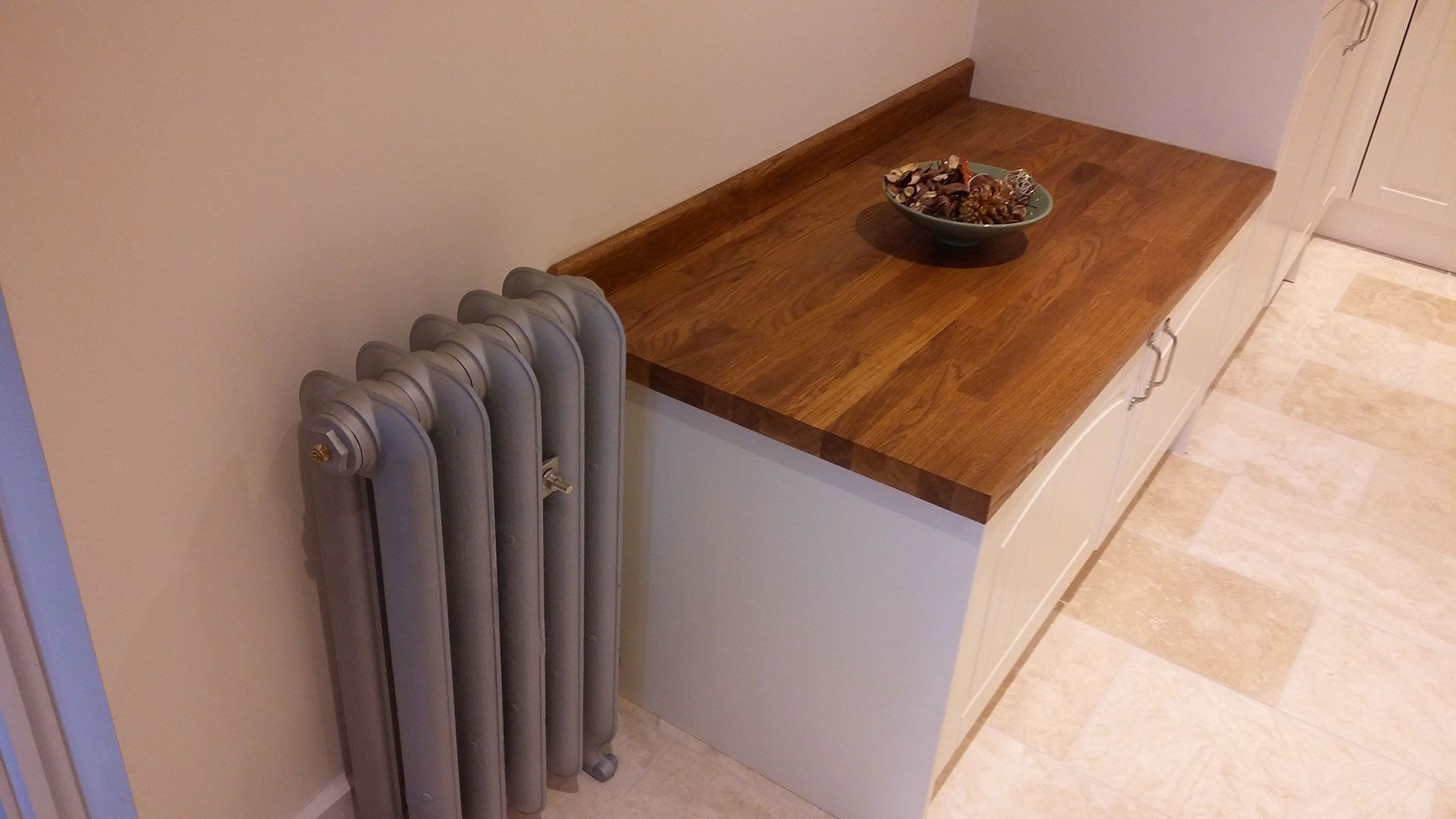 A radiator is sitting next to a wooden counter top.