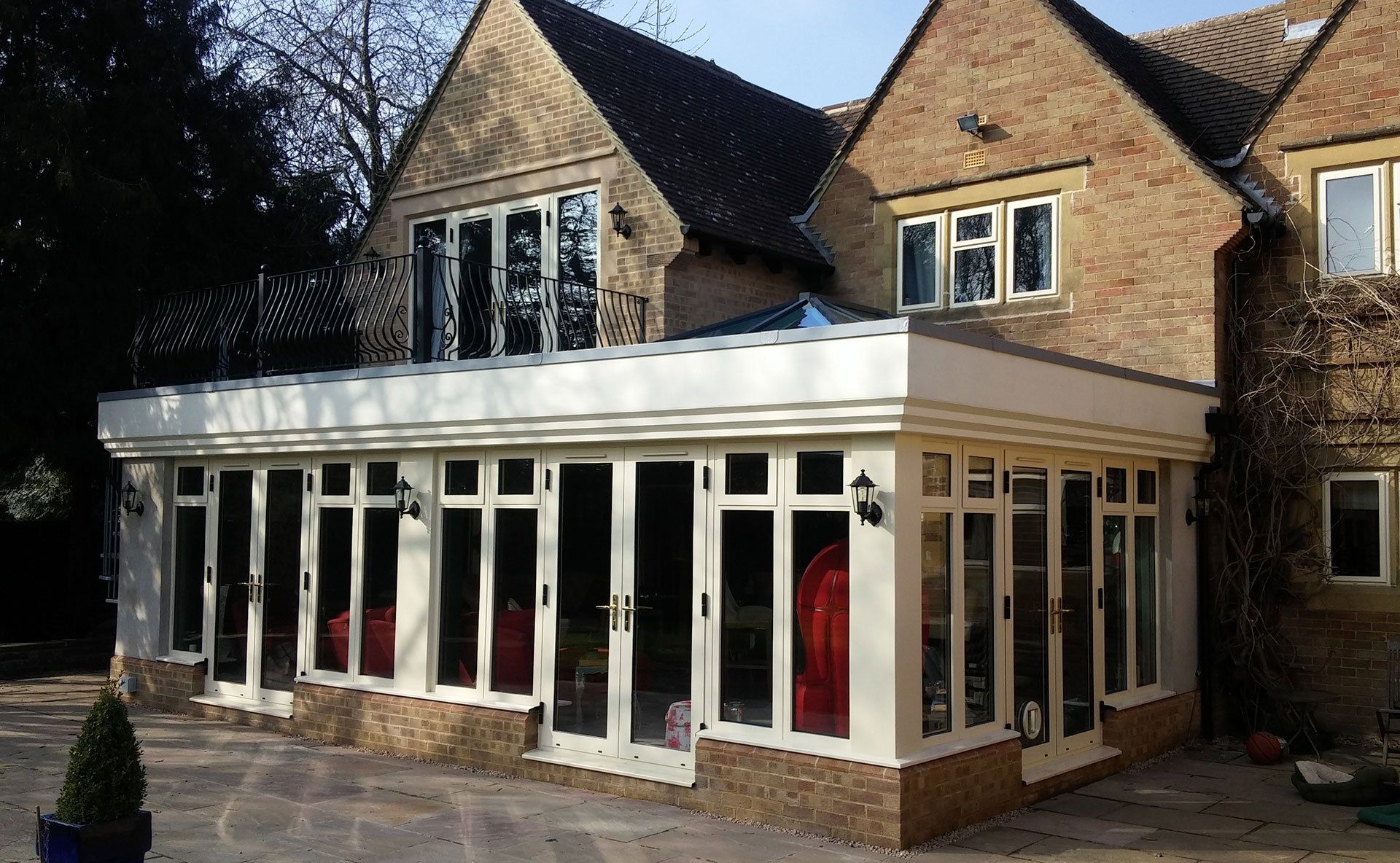 A large brick house with a white extension on the side