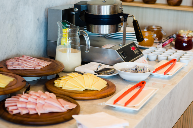 Una mesa de buffet con platos de comida y pinzas encima.