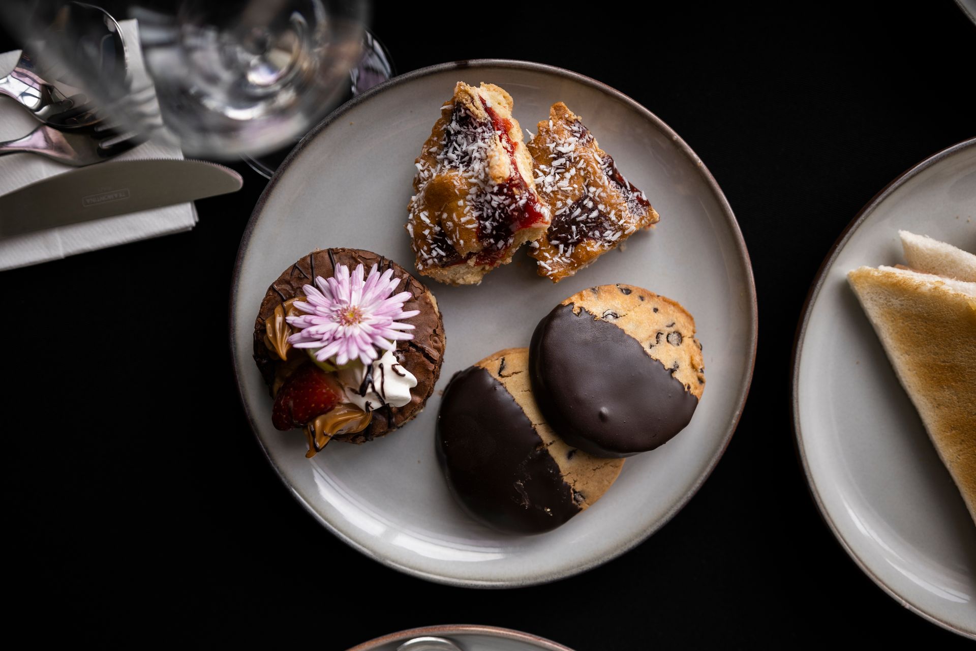 Un plato blanco cubierto con una variedad de postres sobre una mesa.