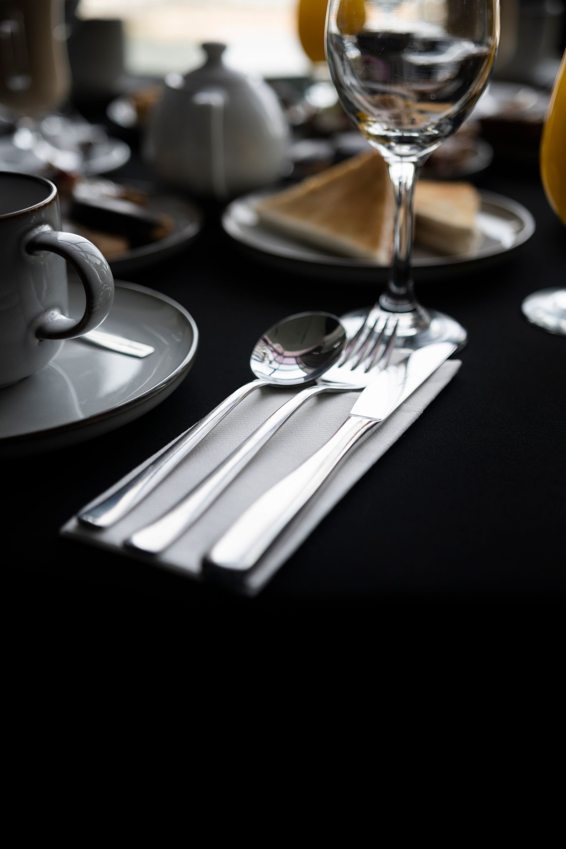 Una mesa con una taza de café y una copa de vino.