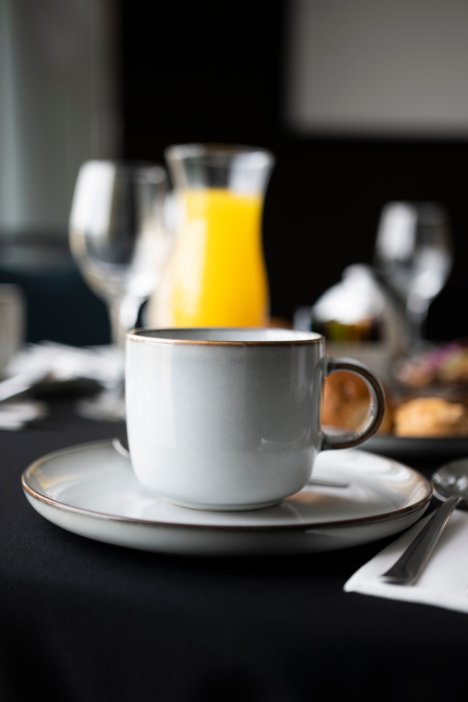 Una taza de café está sobre un platillo sobre una mesa.