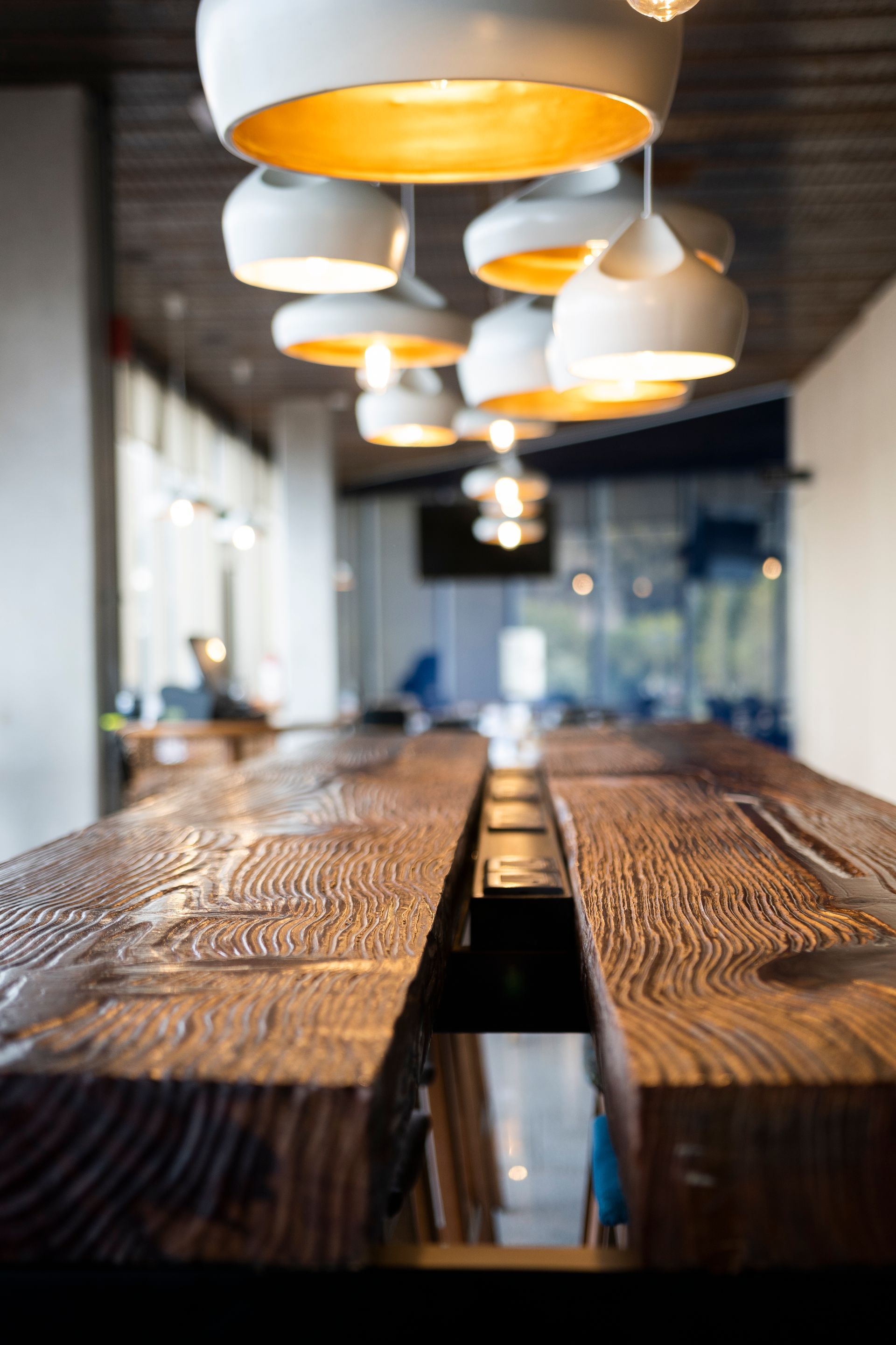Una mesa larga de madera con muchas luces colgando del techo.