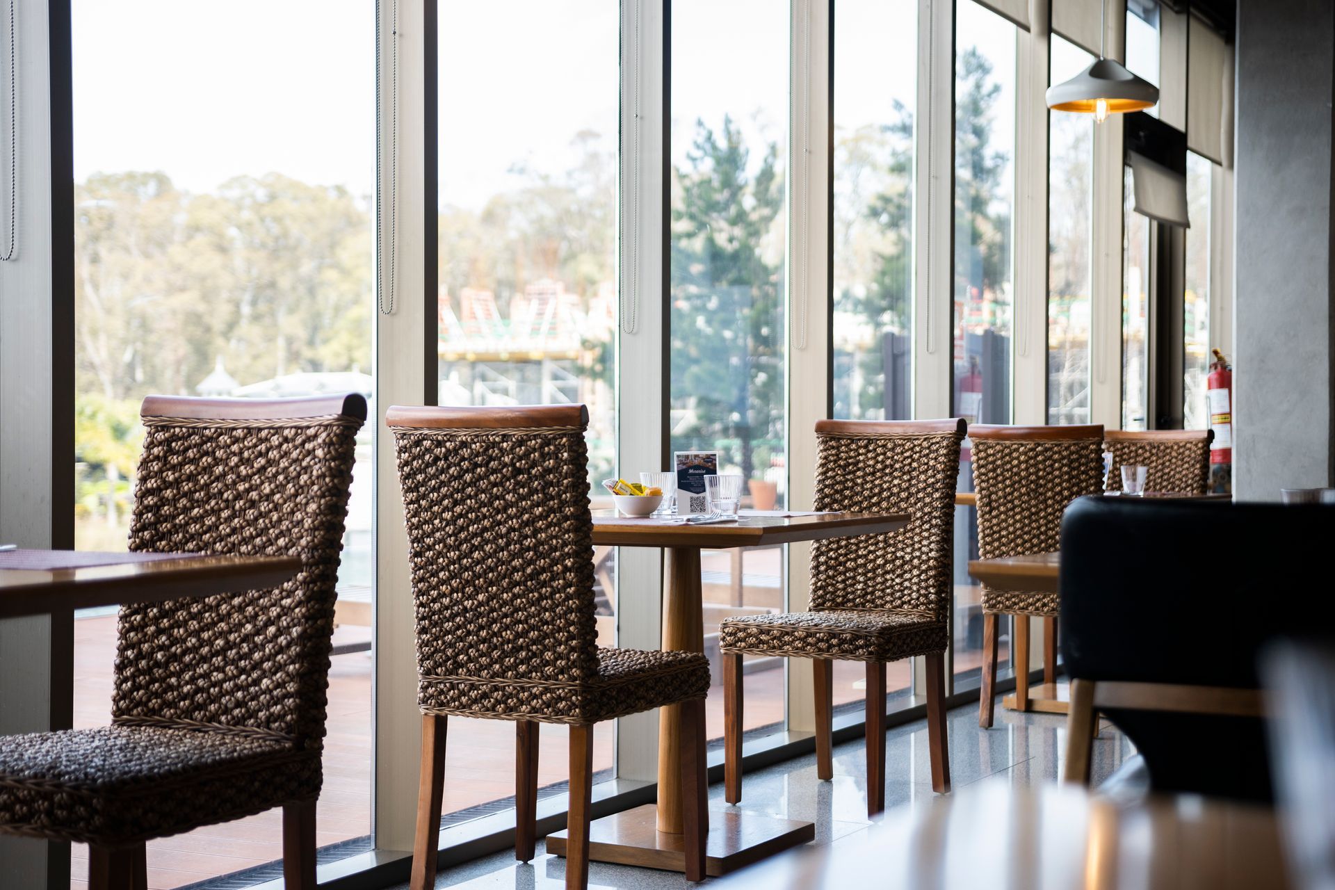 Un restaurante con mesas y sillas frente a un gran ventanal.