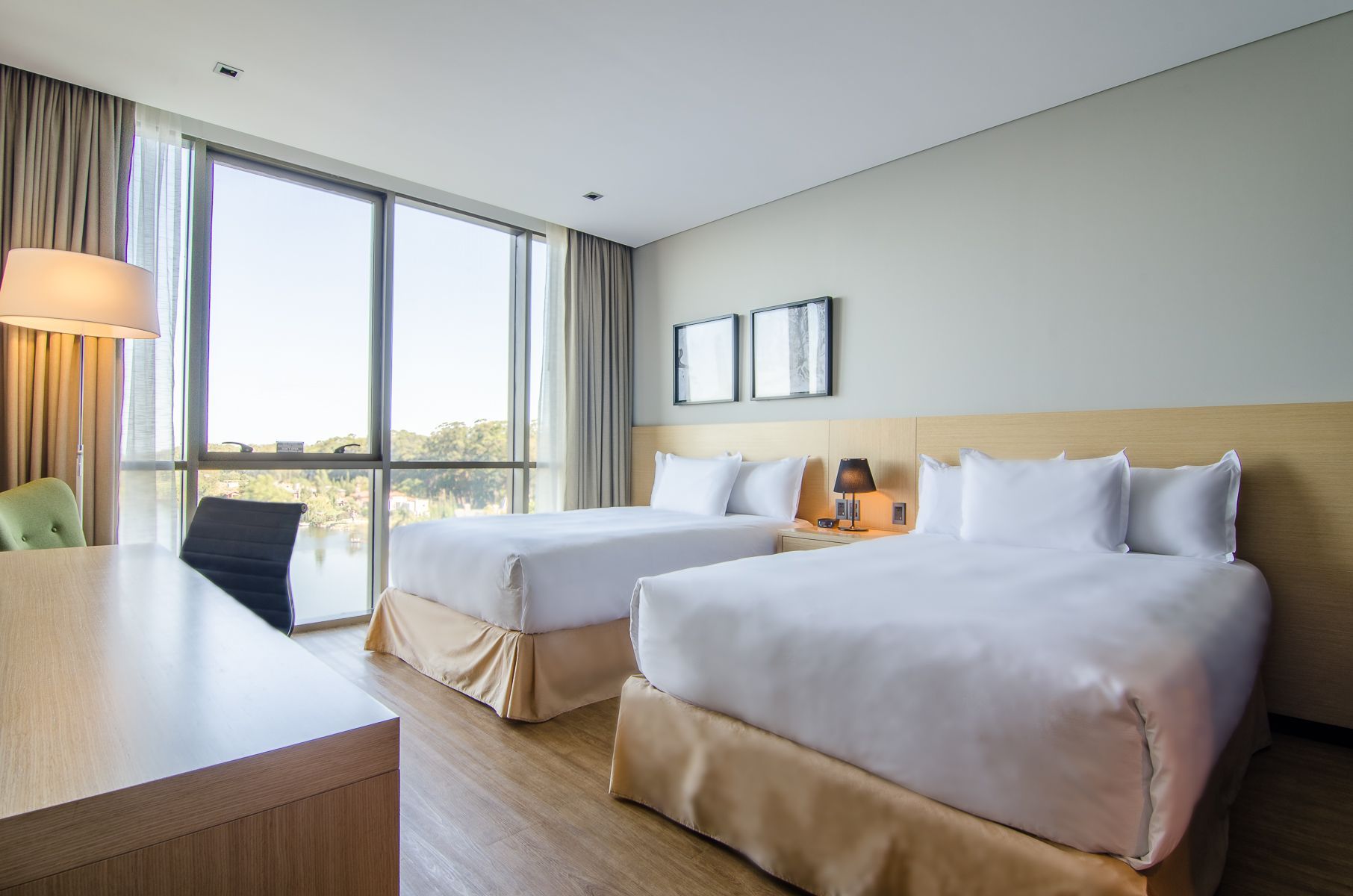 Una habitación de hotel con cama, silla, lámpara y ventana.