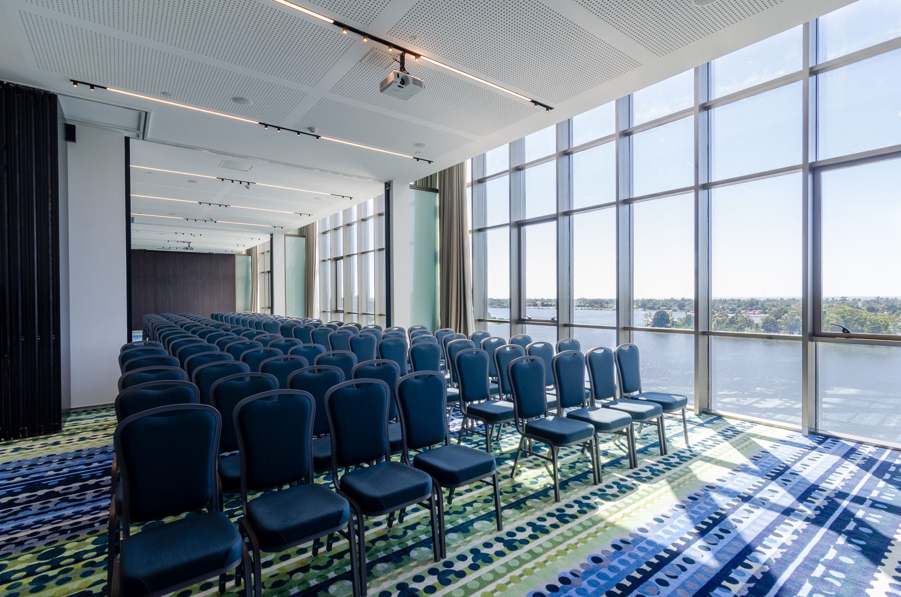 Sala de eventos con muchas sillas y ventanas.