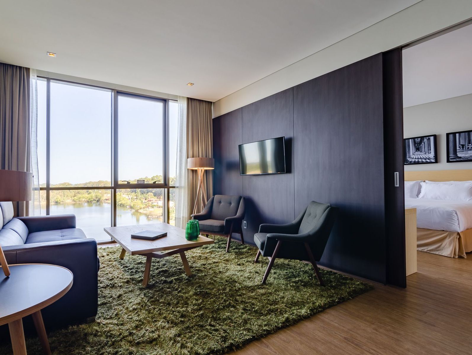 Una habitación de hotel con sofá, sillas, mesa y televisión.