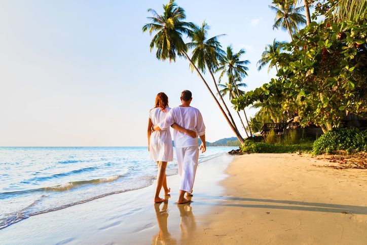 a man and a woman are walking on a beach .