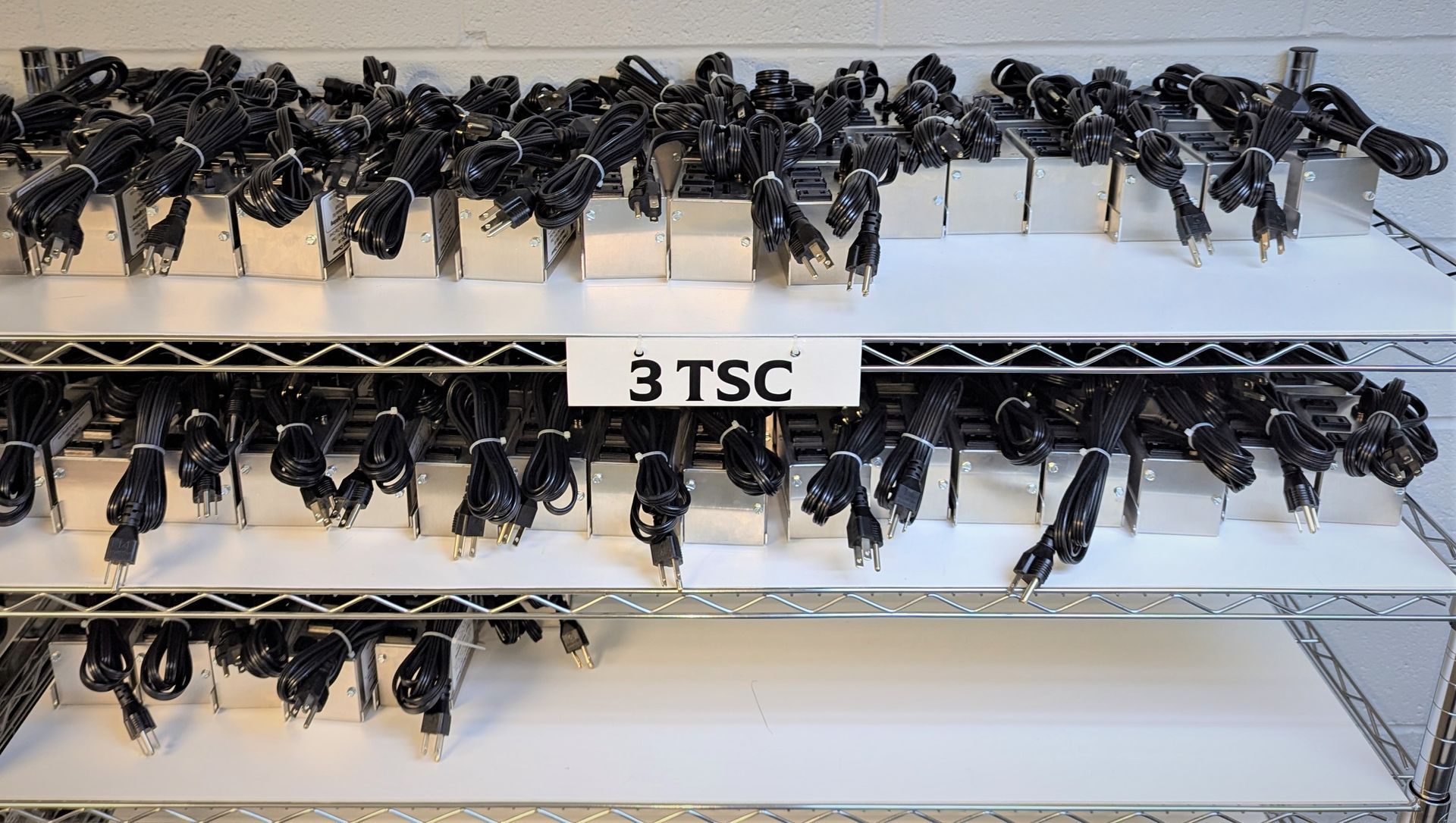 A bunch of keys on a shelf with a sign that says 3 tsc