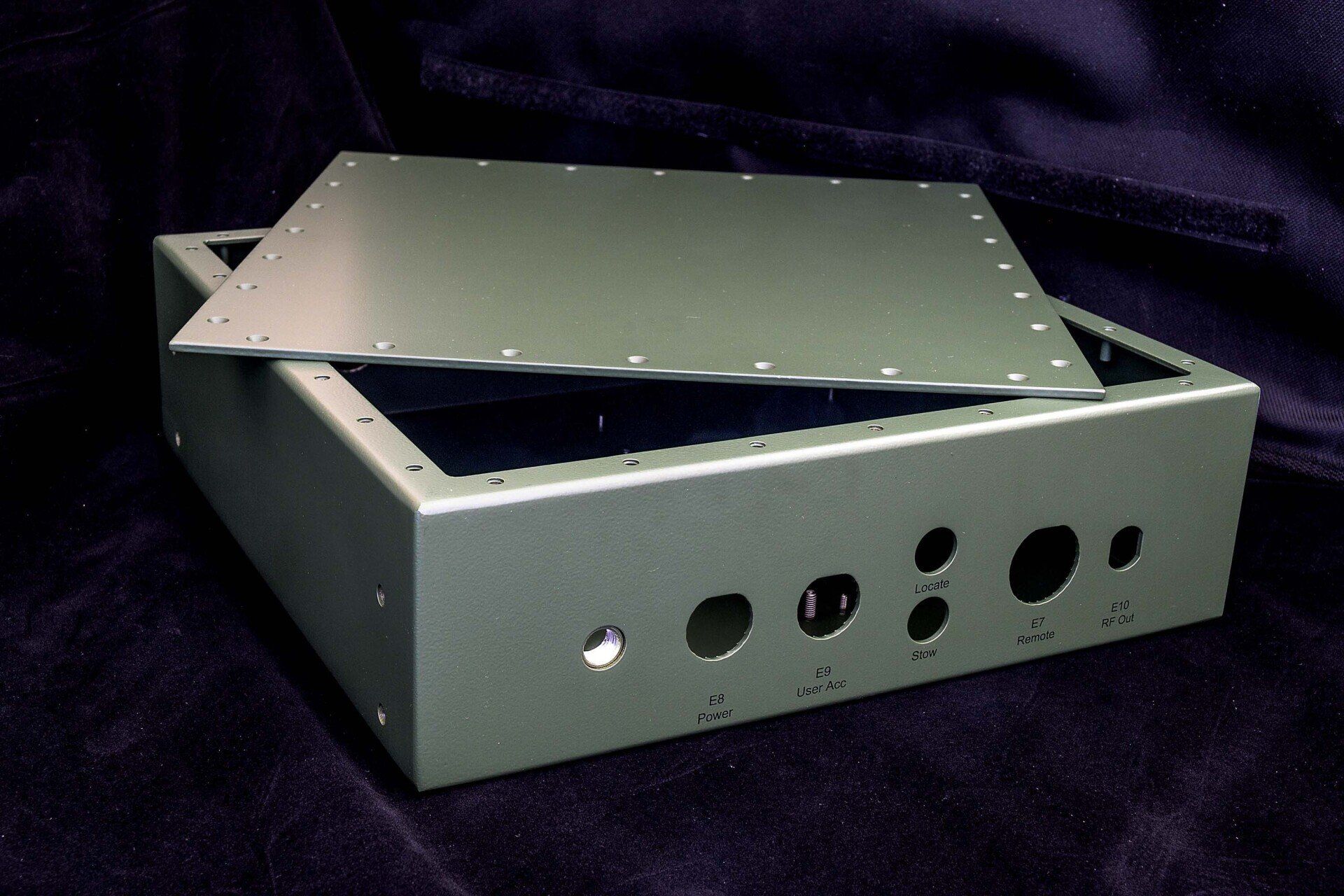 A metal box with holes in it sits on a purple cloth