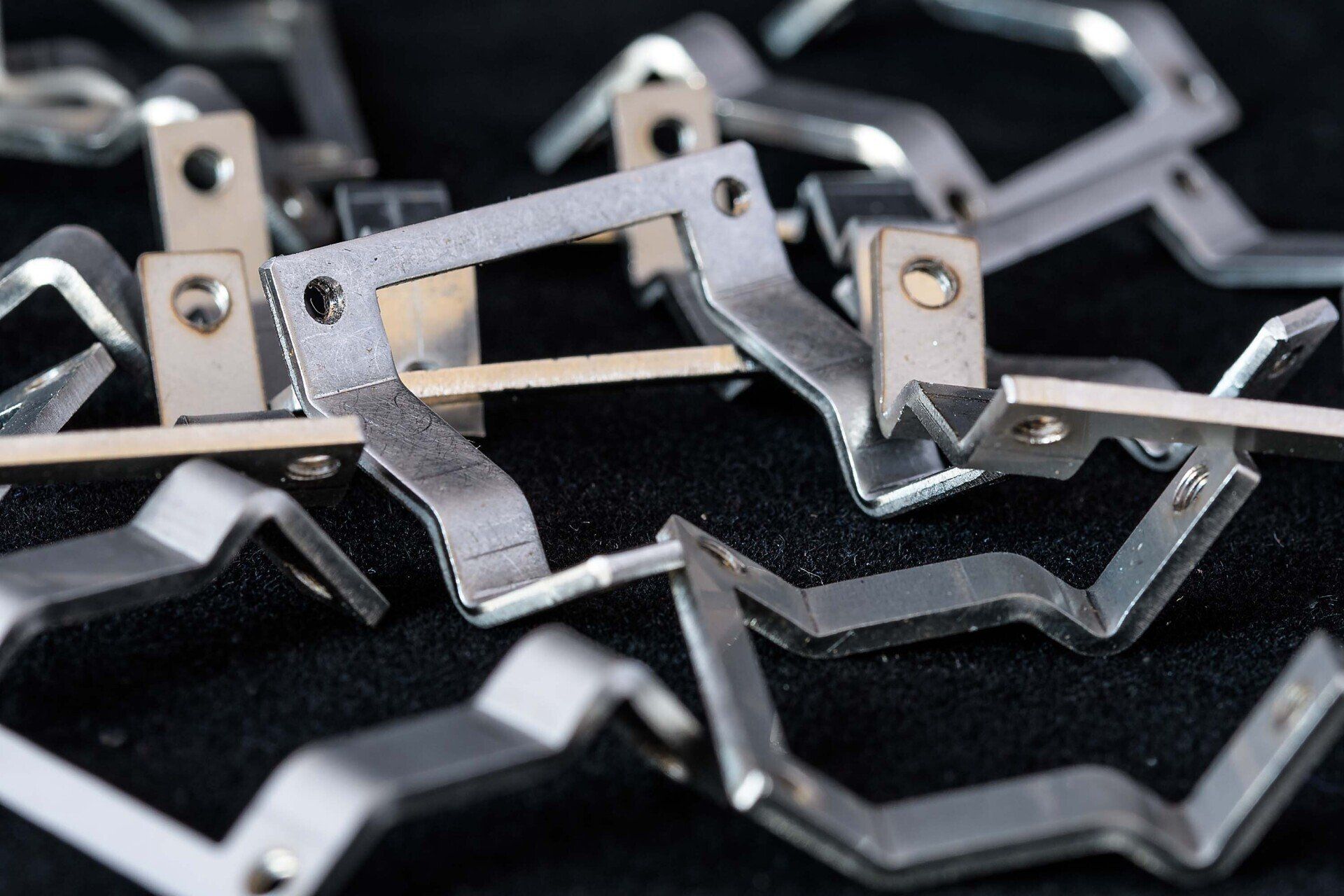 A pile of metal pieces on a black surface