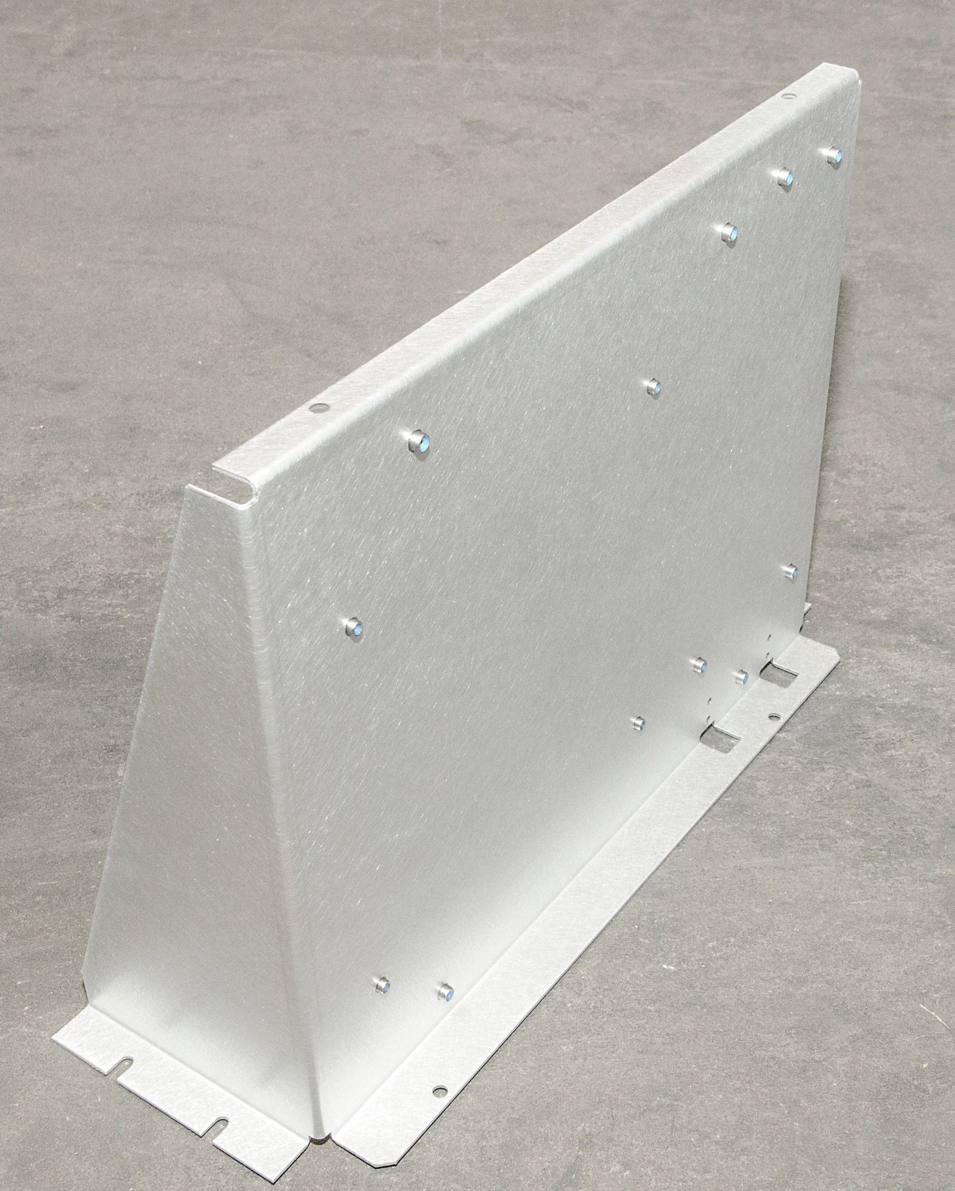 A white metal barrier is sitting on a concrete surface.