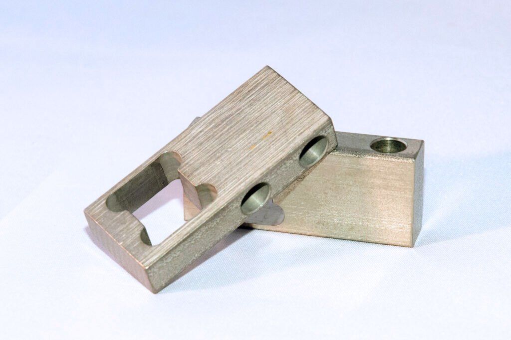 Two pieces of metal are stacked on top of each other on a white surface.