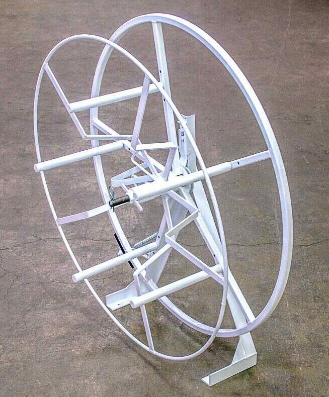 A large white wheel is sitting on a concrete floor.