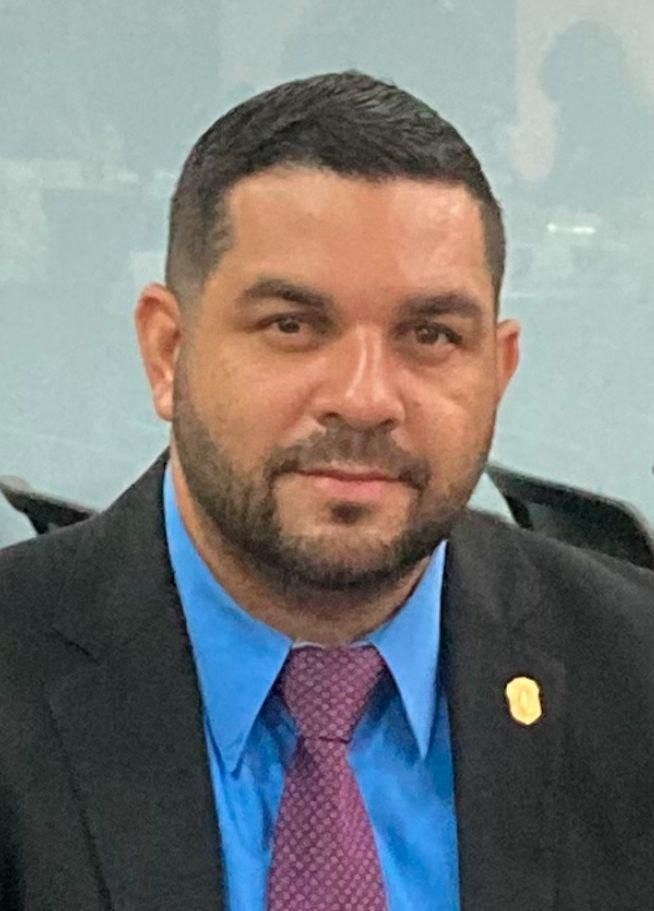 Un hombre con barba lleva traje y corbata.