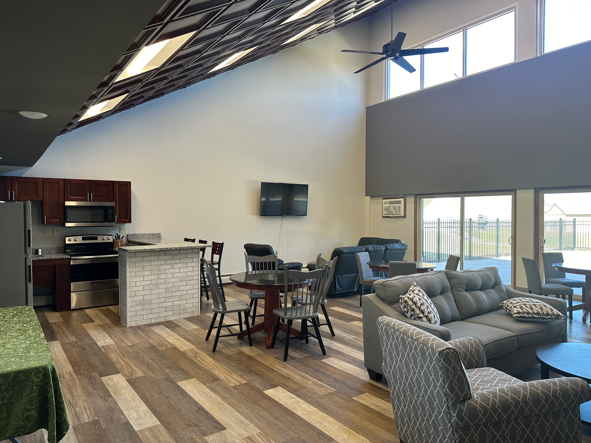 A living room with a couch , chairs , tables and a television.
