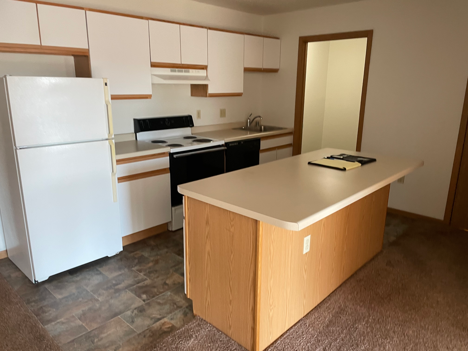An empty kitchen with a large island in the middle