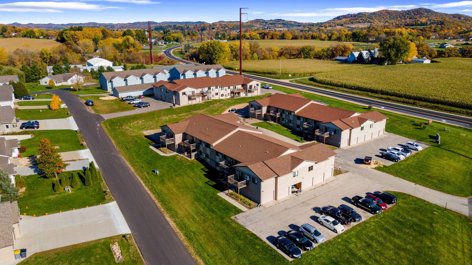 An aerial view of a residential area with a lot of cars parked in front of buildings.