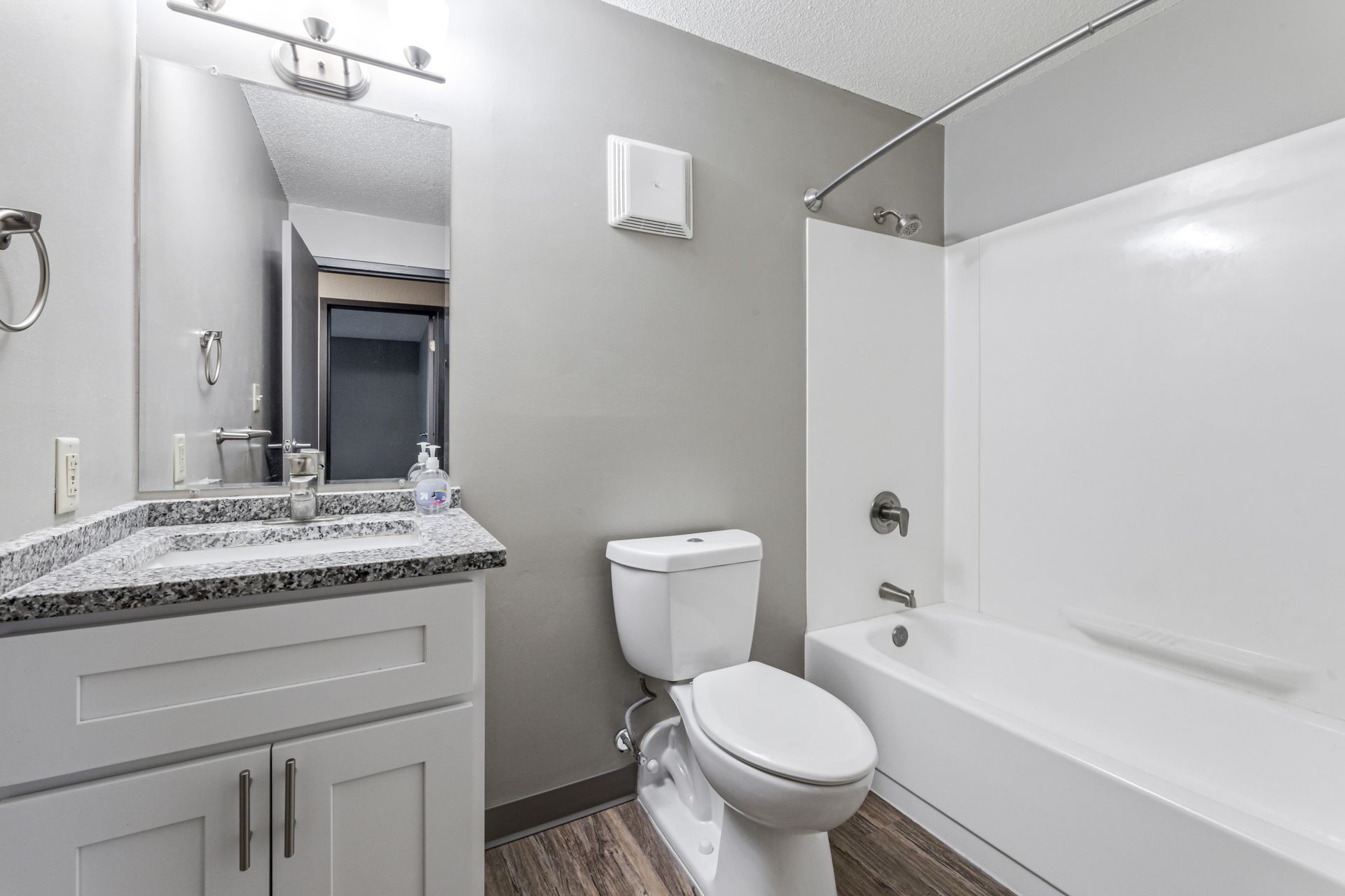 A bathroom with a toilet , sink , and bathtub.