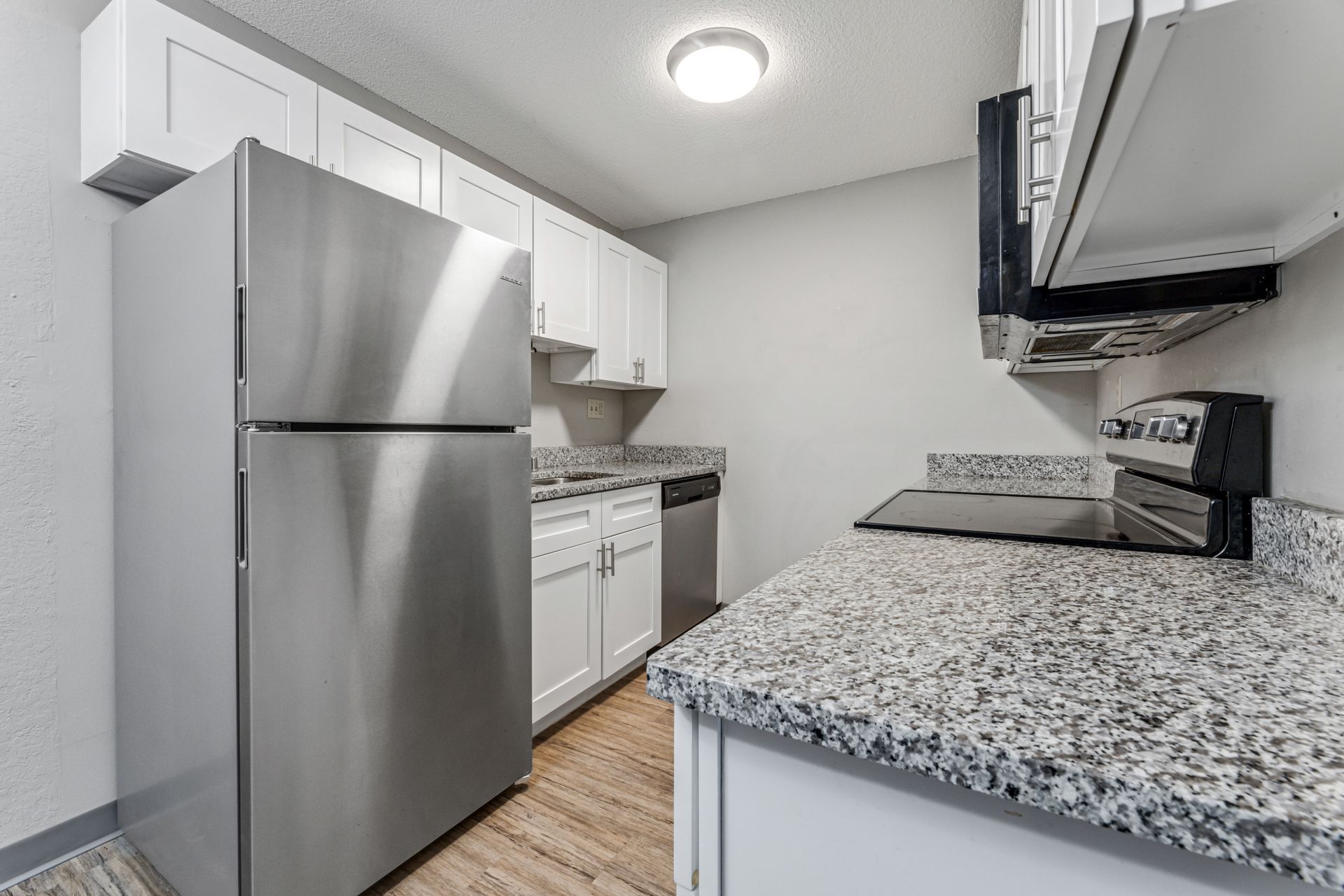 A kitchen with stainless steel appliances and granite counter tops.