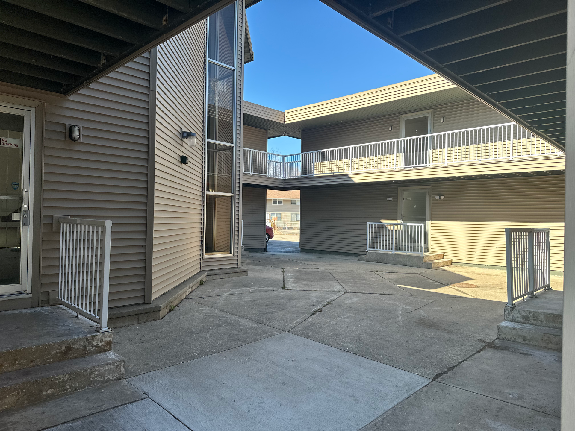 A courtyard between two buildings with stairs and a fire hydrant