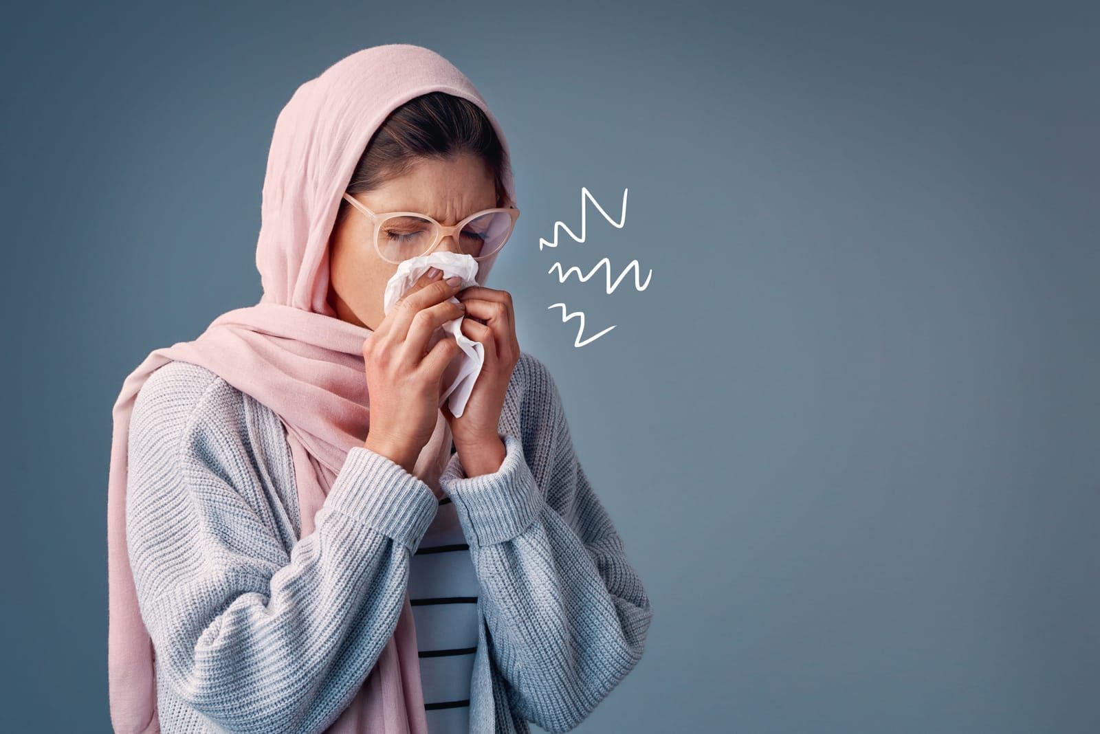 A woman is blowing her nose with a napkin.