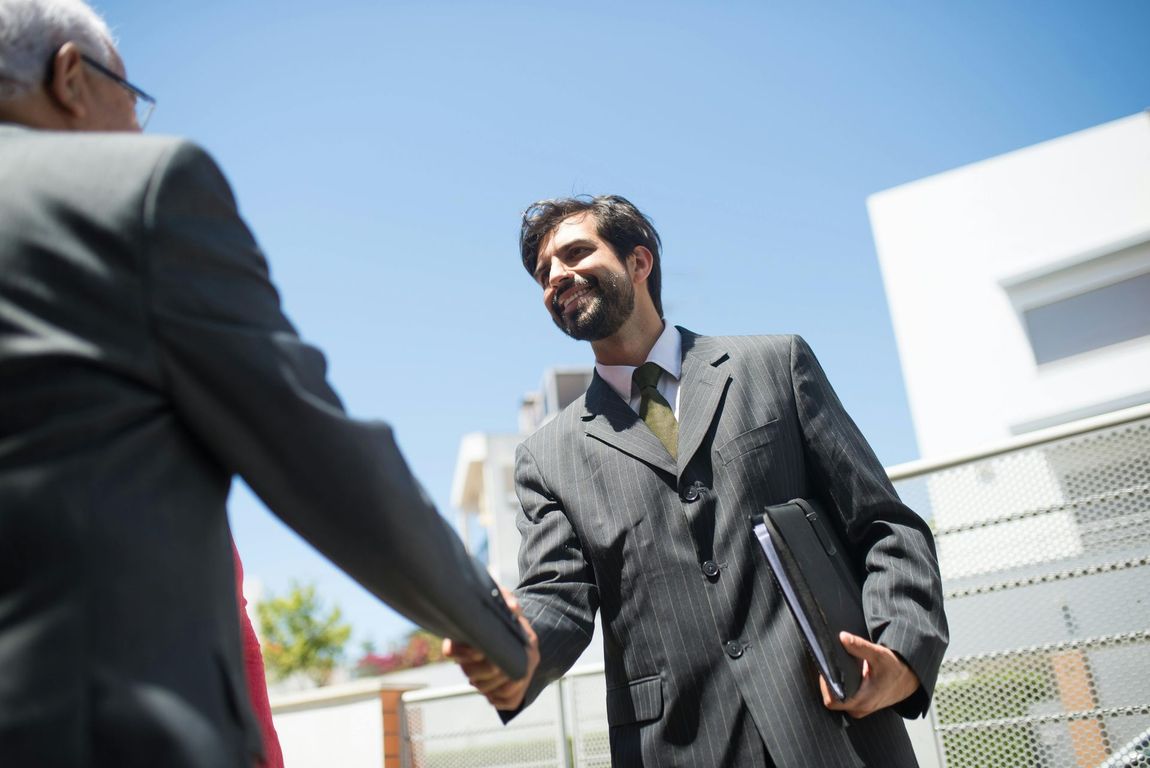 A man in a suit is shaking hands with another man