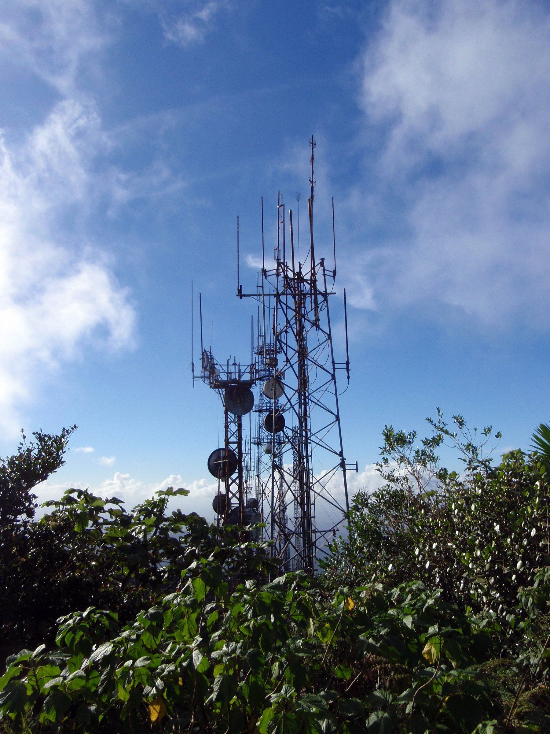 A very tall antenna tower with a blue sky in the background